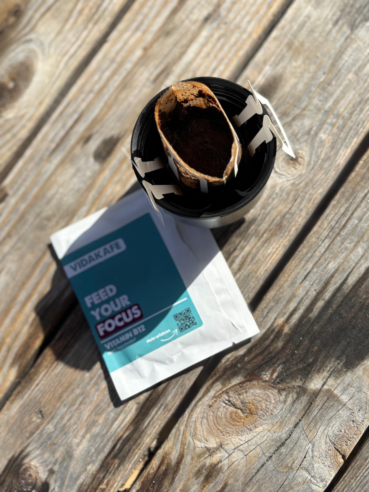 Aufgebrühter Vidakafe Drip Bag auf einem Thermobecher